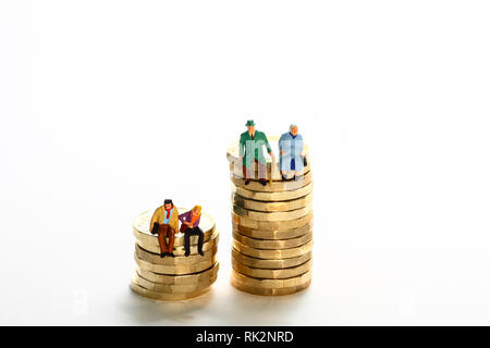 Konzeptuelles Diorama-Bild einer Miniaturfigur Rentnerpaar und Das junge Paar saß auf einem Stapel von Pfund-Münzen Stockfoto