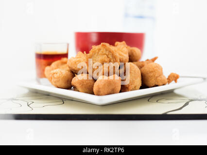 Beliebte nigerianischen Mahlzeiten - Akara in einem weißen und pap mit rotem Pfeffer Sauce serviert. Stockfoto