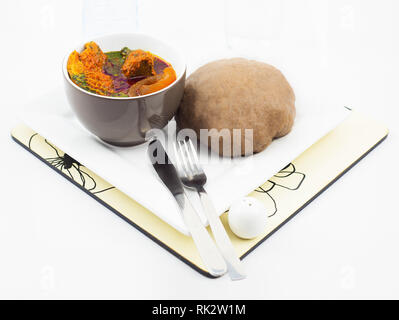 Beliebte nigerianischen Mahlzeiten - Ewedu Gbegiri und verschiedene Fleisch, Suppe mit Amala in einem weißen Teller serviert Stockfoto