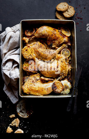 Gebratene Hähnchenschenkel mit in Scheiben geschnittenen Knoblauch Stockfoto