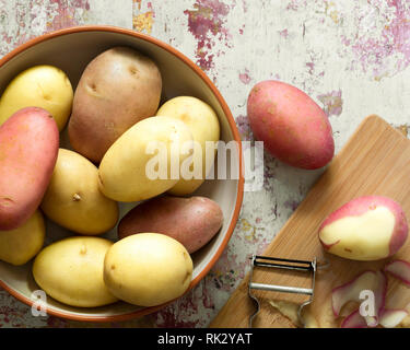 Gewaschene rote und weiße Kartoffeln in eine Schüssel geben und mit der Haut teilweise geschält. Stockfoto