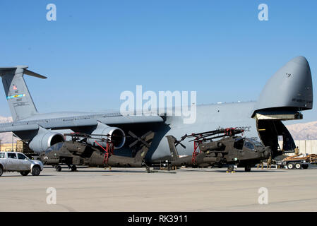 Flieger, Soldaten und Mitarbeiter bereiten Apache Hubschrauber in eine C-5 am Flughafen Bagram, Afghanistan, auf Feb 7, 2019 Last. Die 455Th Air Expeditionary Wing besteht aus mehr als 2.100 Flieger in Bagram, Jalalabad und Kandahar Flugplätze. (U.S. Air Force Foto von der SrA Jean-Paul Arnaud-Marquez) Stockfoto