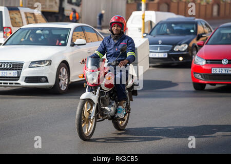 Johannesburg, Südafrika, 24. August - 2018: Lieferung Kurier auf Motorrad im Verkehr. Stockfoto