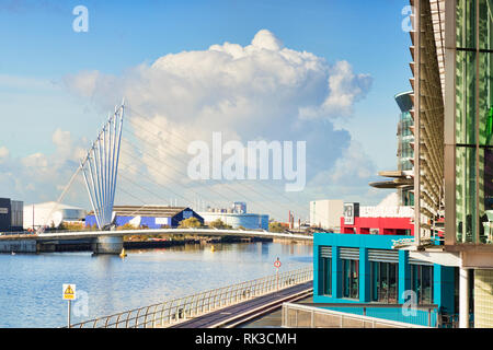 2. November 2018: Salford Quays, Manchester, UK-Media City Fußgängerbrücke, und einem großen weißen Wolke hinter sich. Stockfoto