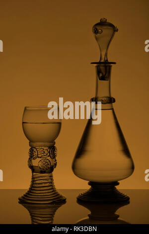 Mittleres Alter rummer Wein Glas und Flasche auf dem weißen Hintergrund. Schwarzweiß, Schwarzweiß-Bild. Stockfoto