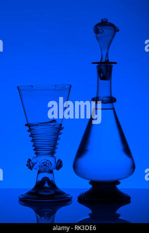 Mittleres Alter rummer Wein Glas und Flasche auf dem weißen Hintergrund. Schwarzweiß, Schwarzweiß-Bild. Stockfoto