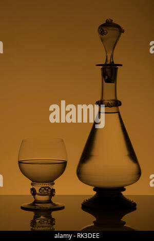 Mittleres Alter rummer Wein Glas und Flasche auf dem weißen Hintergrund. Schwarzweiß, Schwarzweiß-Bild. Stockfoto