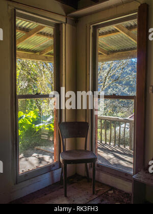 Leeren Stuhl in der Ecke von der Windows, Sonnenschein auf der Veranda, verlassenes Haus, Ahu Ahu Ohu, Whanganui River, New Zealand Stockfoto