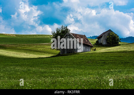 Malerische Aussicht über die deutsche Landschaft rund um das Dorf Kappel mit zwei alten hölzernen Schuppen auf die grünen Hügel Stockfoto