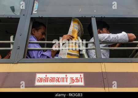 Ein Mann liest eine Zeitung auf einen Bus auf dem Weg in Chennai, der viertgrößten Stadt in Indien zu arbeiten Stockfoto