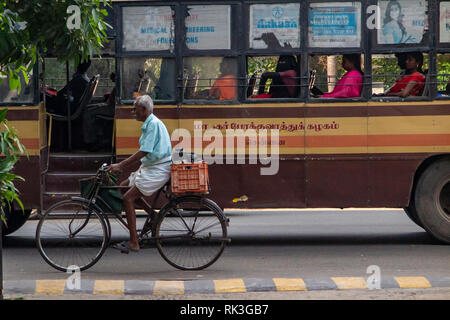 Ein Bus überholt ein Mann auf einem Fahrrad in Chennai, der viertgrößten Stadt in Indien Stockfoto