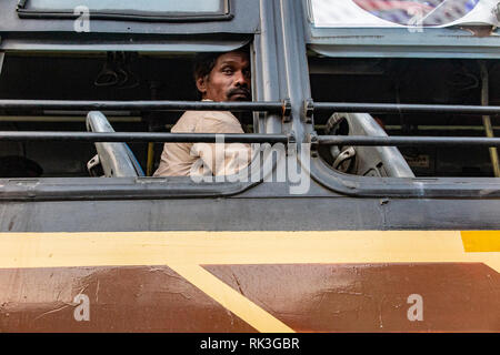 Ein Mann auf einem Bus schaut direkt in die Kamera in Chennai, der viertgrößten Stadt in Indien Stockfoto