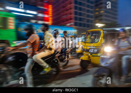 Abendliche rush hour mit vielen Motorräder und ein Tuk Tuk in Chennai, Südindien Stockfoto