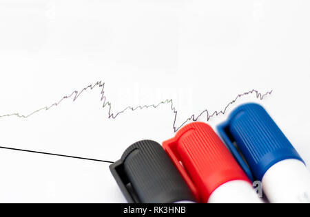 Bündel von Stiften neben Grafik, schnelle Änderungen in Geld/Aktien/Finanzen Stockfoto