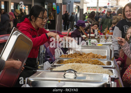 Woking, Surrey, Großbritannien. 9. Februar, 2019. Woking Zentrum feierte das Chinesische Neue Jahr des Schweins heute mit bunten Paraden und Shows. Besucher der Stadt genossen auch auf Marktständen verkaufen traditionelle chinesische Kunst und Handwerk, wie zum Beispiel Kalligraphie suchen, und Essen. Stockfoto