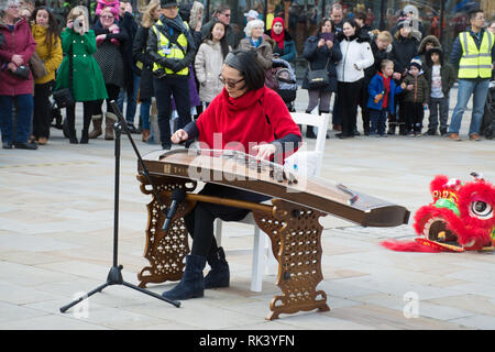 Woking, Surrey, Großbritannien. 9. Februar, 2019. Woking Zentrum feierte das Chinesische Neue Jahr des Schweins heute mit bunten Paraden und Shows. Ein solo spielen oder auf der chinesische zither Guzheng. Stockfoto