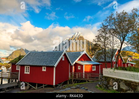 Iconic Rorbu mit Mount Olstind (Olstinden) im Hintergrund, Reine, Moskenes, Nordland, Lofoten, Norwegen Stockfoto