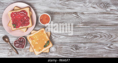 Leckere Toasts mit verschiedenen süßen Marmeladen auf grauem Hintergrund. Copyspace für Ihren Text, Banner Stockfoto