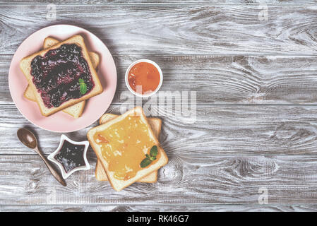 Leckere Toasts mit verschiedenen süßen Marmeladen auf grauem Hintergrund. Copyspace für Ihren Text, Banner Stockfoto