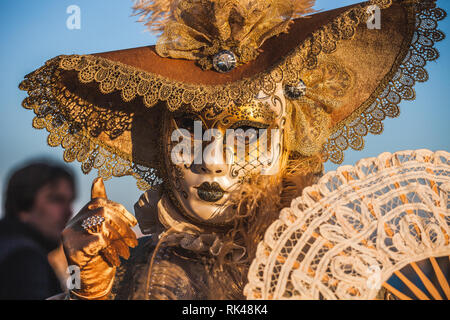 Venedig, Italien - 10 Februar 2018: in der Nähe von Golden gekleidete Karneval Maske mit Fantasy Motive und Ventilator geschmückt. Stockfoto