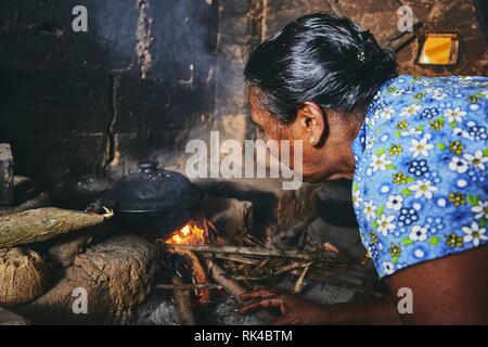 Ländliche Frau Zubereitung von Speisen in der traditionellen Küche zu Hause. Das häusliche Leben in Sri Lanka. Stockfoto