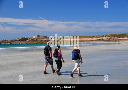 Drei Wanderer Wandern in Vazon Bay in Richtung Fort Hommet, Guernsey, Channel Islands.de. Stockfoto