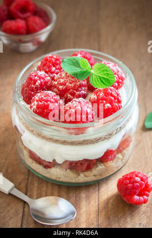 Himbeere layered Dessert - käsekuchen in Glas Glas mit frischen Himbeeren und Frischkäse. Gesunde hausgemachte Sommer berry Dessert. Stockfoto