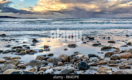 Nahaufnahme auf Kieselsteinen von Wellen gebadet am Ufer des ruhigen Meer nach dem Sturm, mit einem Himmel voller bedrohliche Wolken Stockfoto