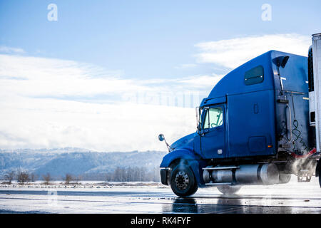 Big Rig pro Long Haul blue Semi Truck Traktor Transport von kommerziellen Ladung im Kühlschrank Auflieger gehen auf das Nass glänzende Straße mit Wasser aus Stockfoto