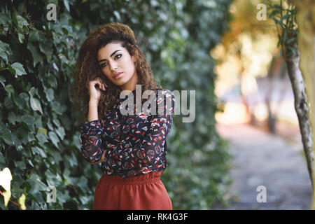 Schöne junge arabische Frau mit schwarzen Locken Frisur. Stockfoto