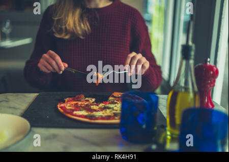 Eine junge Frau ist essen Pizza im Restaurant Stockfoto