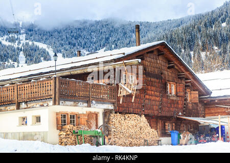 Landhaus mit einer Lieferung von Brennholz für den Winter in den Bergen im Hintergrund. Skigebiet Laax. Schweiz Stockfoto