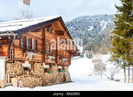 Landhaus mit einer Lieferung von Brennholz für den Winter in den Bergen im Hintergrund. Skigebiet Laax. Schweiz Stockfoto