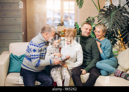 Großvater ist das Erzählen von Geschichten zu seinem Sohn, Töchter und graddaughter über seine Jugend. alter Mann denkt an alte Zeiten. Stockfoto