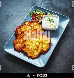 Frittierte Deutsch Kartoffelpuffer mit cremig Dip auf einer Schüssel für einen leckeren Aperitif in einem hohen Winkel serviert Stockfoto