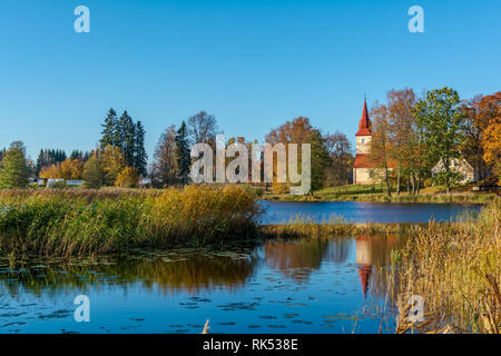 Araisi lutherischen Kirche stehend auf die ruhige See im sonnigen Herbsttag. Alte Kirche in der ruhigen blauen glatte Oberfläche des Sees widerspiegelt. Stockfoto