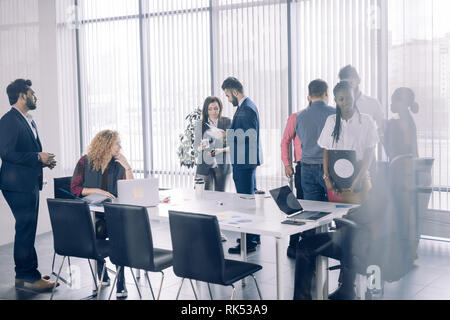 Positive multirassischen diverse Geschäftsleute in formalen und Casual Wear diskutieren Forum Themen und Eindrücke auszutauschen beim Stehen in der Konferen Stockfoto