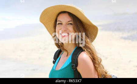 Abenteuer Mädchen mit Rucksack und Strohhut in die Kamera schaut. Junge Frau Erkundung Kanarischen Küste mit Sanddünen von Lanzarote, Spanien. Panoramablick Stockfoto