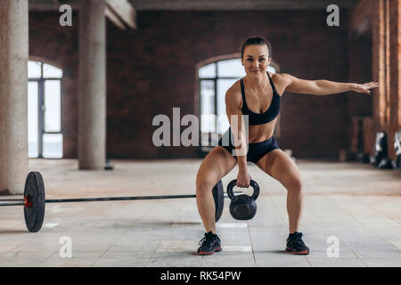 Happy fit verschwitzten Frau Trainieren mit kettlebell, Kreuz fit Trainings im Innenbereich. Kopieren. in voller Länge Foto, Hobby, Lifestyle, Interesse, Ersatzteil t Stockfoto