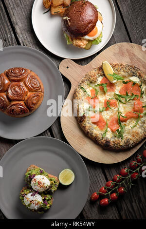 Mittagessen Auswahl, Pizza, Burger, pochierte Eier und Zimt Kuchen Stockfoto