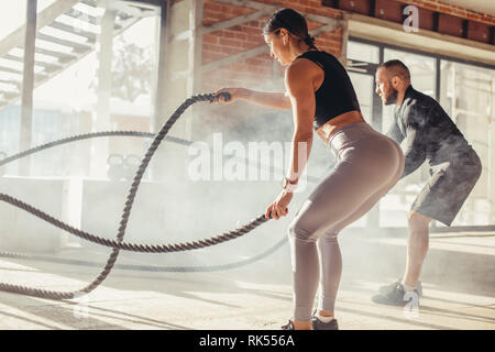 Junge fitness Paar in Sportkleidung, crossfit Herz-Kreislauf-Training mit Training Seil an Gym, gesunden Sport Lifestyle, Sport Konzept. Stockfoto