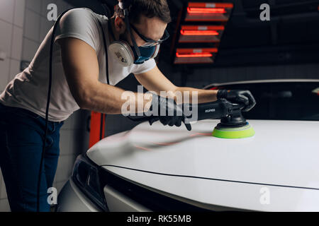 Junger Mann Testen einer elektrischen Auto Poliermaschine, Foto schliessen. letzten Schliff Stockfoto