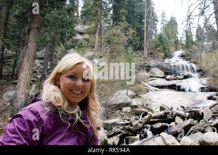 Blonde Wanderer stellt von Whitney Portal fällt, einen Wasserfall in der Nähe der Trailhead für die Mt. Whitney in Kalifornien Stockfoto