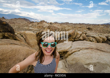 Frau stellt sich auf eine Wanderung durch die riesigen Felsbrocken der Alabama Hills, Kalifornien Stockfoto