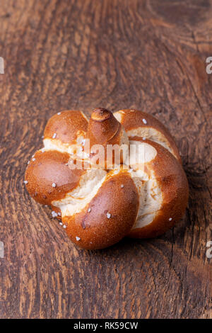 Einzelne bayerische Brezel auf Holz Stockfoto