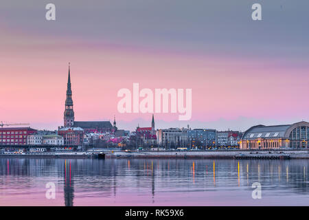 Nacht Blick auf die beleuchtete Riverside mit Reflexion auf dem Fluss in Riga, Lettland Stockfoto