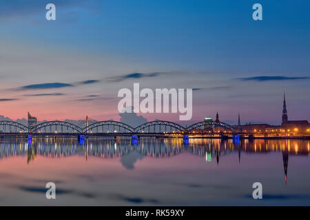 Nacht Blick auf die beleuchtete Riverside mit Reflexion auf dem Fluss in Riga, Lettland Stockfoto