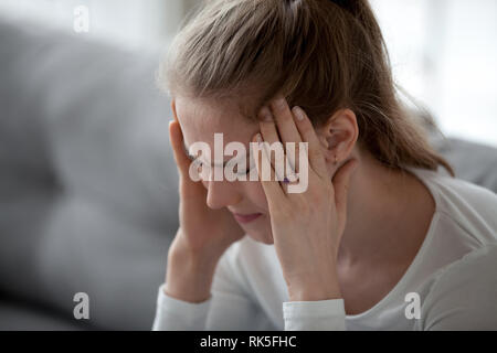Junge kranke Frau mit starken schreckliche Kopfschmerzen Schläfen massieren Betonte Stockfoto