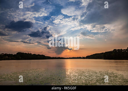 Atemberaubenden Sonnenuntergang im Sommer See mit dynamischen Wolken Stockfoto