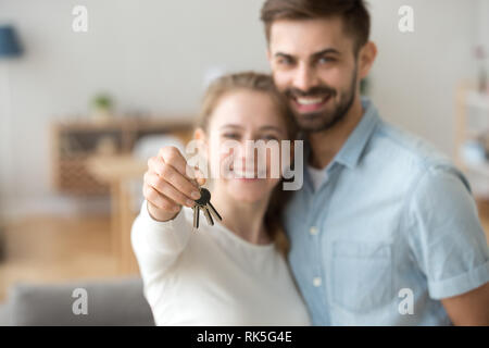 Glückliche junge verheiratete Familie Paar hält Schlüssel zur neuen Wohnung Stockfoto